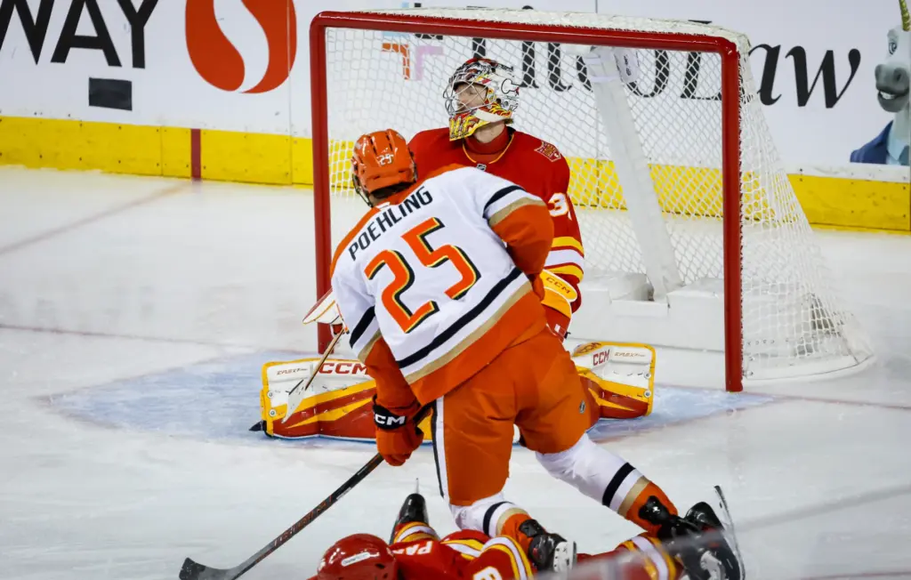Ducks’ Ryan Poehling scores on Calgary Flames goalie Dustin Wolf...