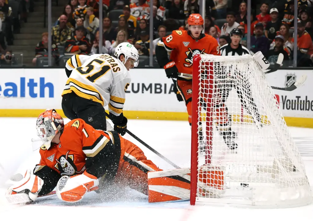 The Boston Bruins’ Matthew Poitras (51) scores behind Ducks goaltender...