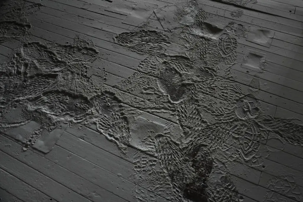Buckwheat dust and footprints cover the floor near equipment.