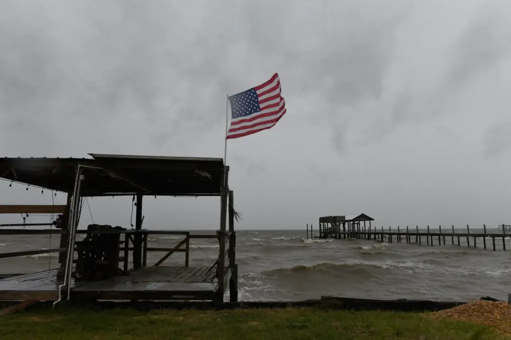An American flag flaps in the wind generated by the...