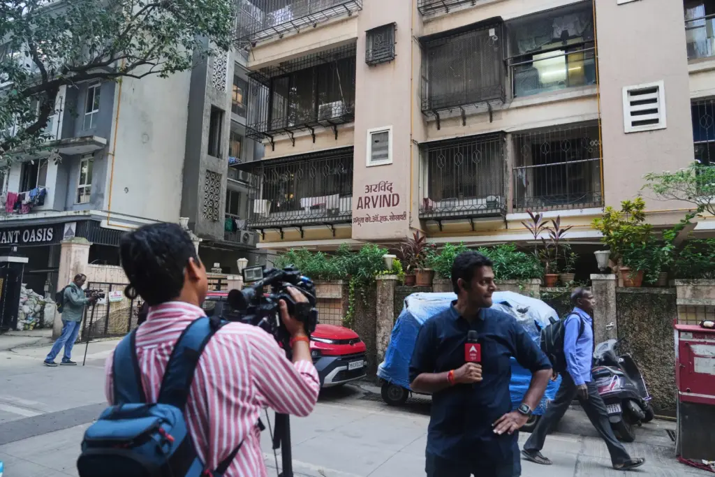 News media personnel stand outside the building where relatives of Smit Machchhar lived.