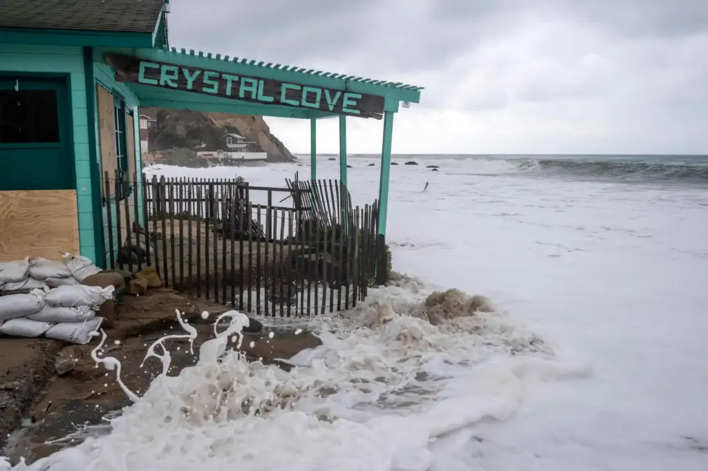 Waves crash onto one of the historic cottages at Crystal...