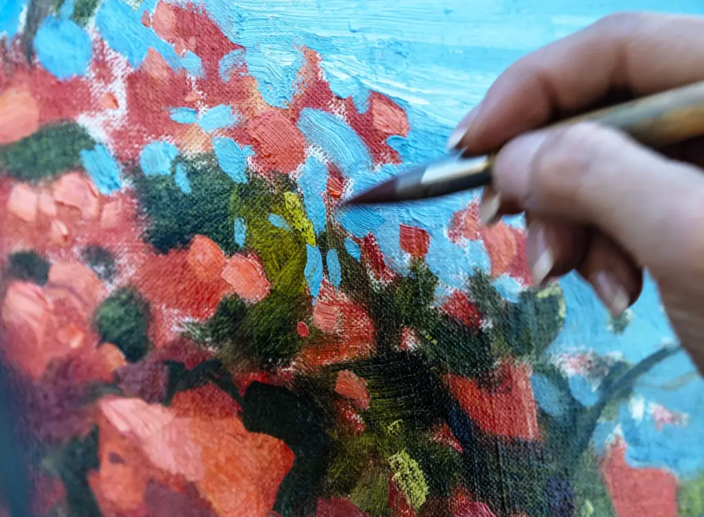 Artist Kathleen Hudson adds details to her painting of a...