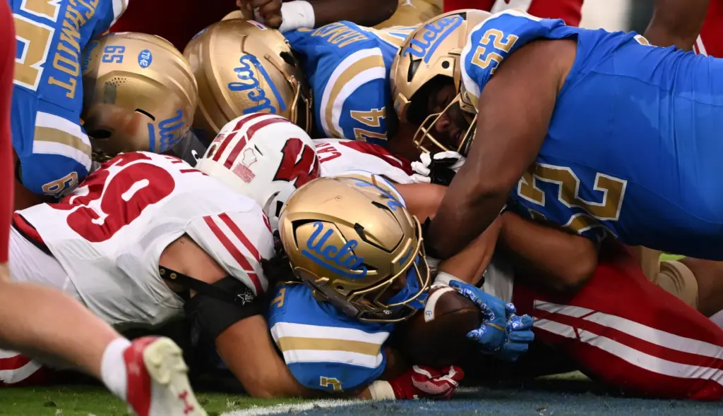 Running back Wayne Knight #3 of the UCLA Bruins runs...