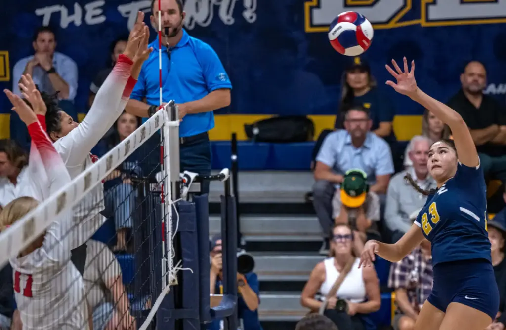 Crean Lutheran opposite hitter Petra Curry (23) hits the ball...