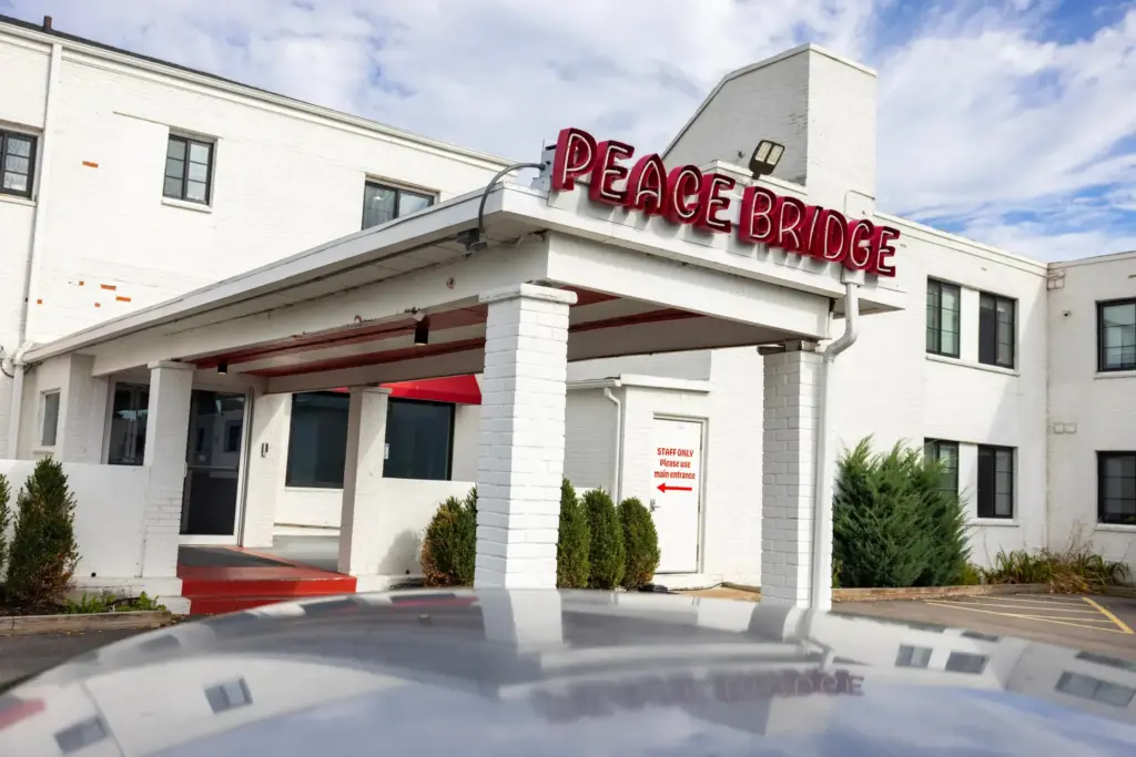 A sign is displayed for Peace Bridge Place apartments that...