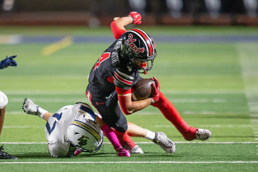 Hart High School’s Matix Frithsmith (4) is tackled by West...