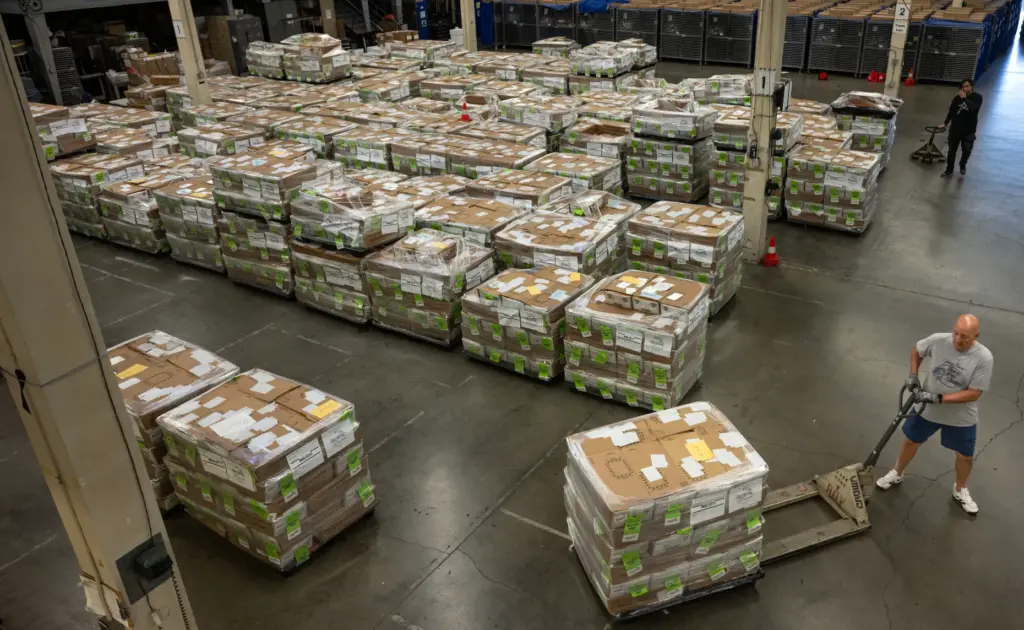Workers move pallets of ballots — more than 1.9 million...