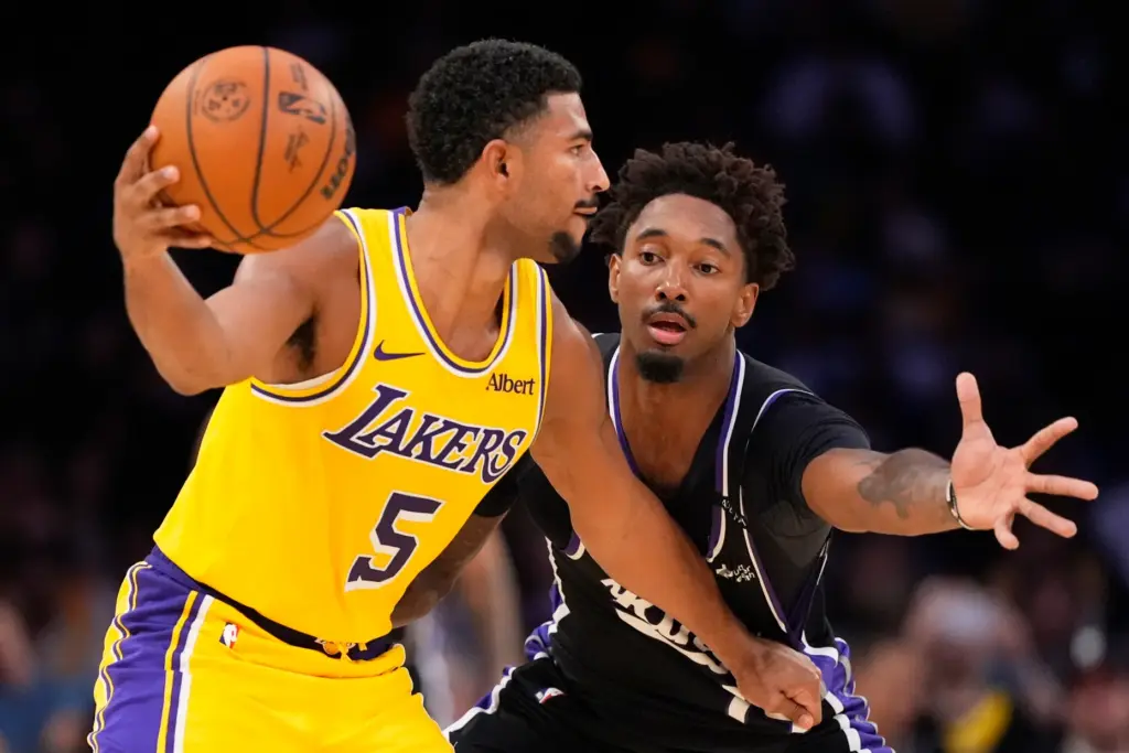 Lakers guard Quentin Grimes, left, looks to pass the ball...