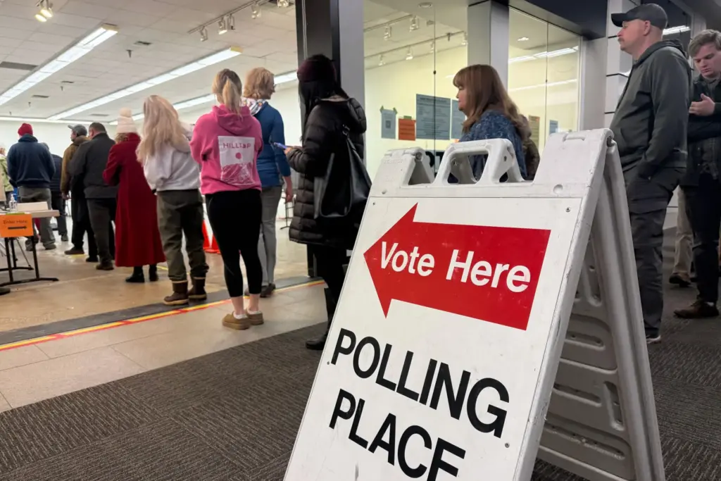 This photo taken with a smart phone, voters stand in...