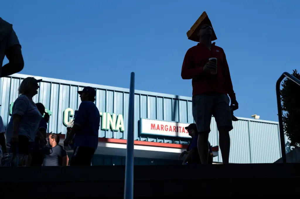 A Milwaukee Brewers fan wearing a cheese head pauses in...