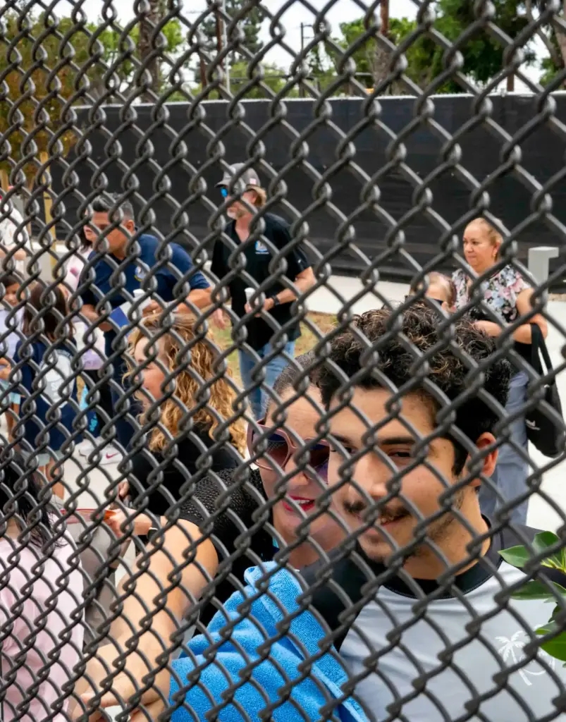 Diana and Wyatt Malfavon peek through the fence while waiting...
