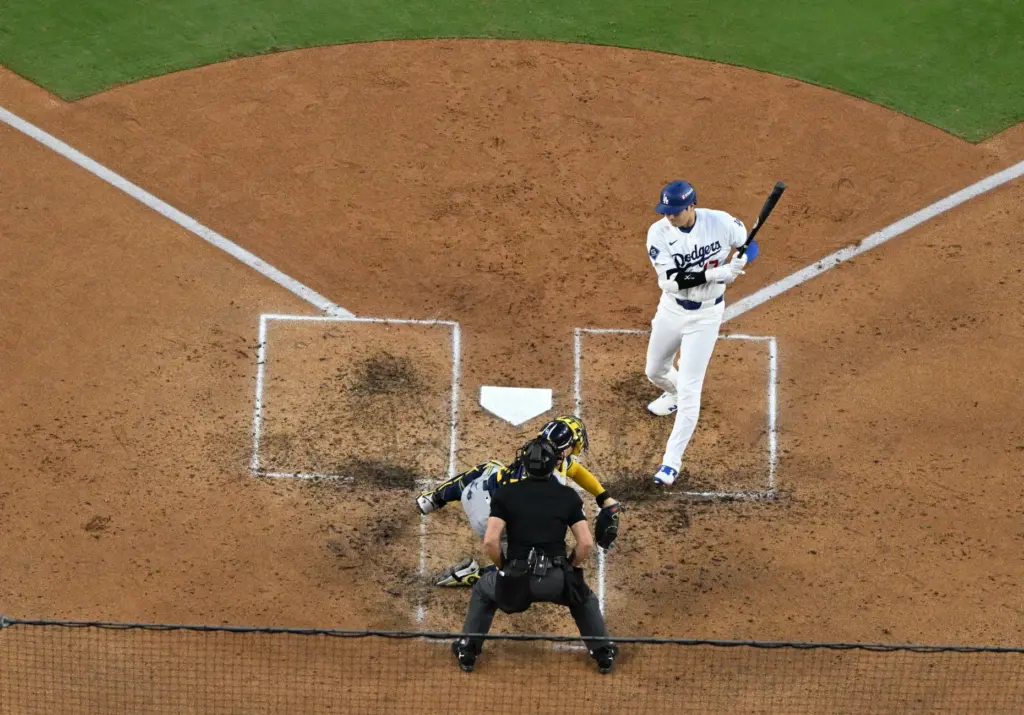 Dodgers star Shohei Ohtani, right, gets hit by a pitch...
