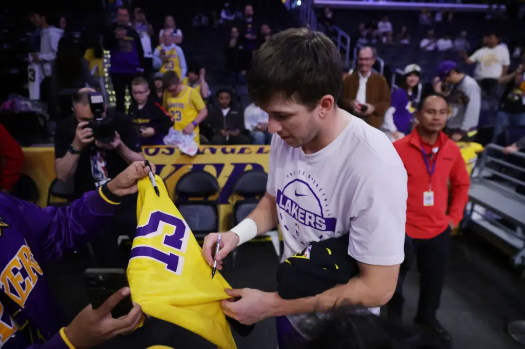Lakers guard Austin Reaves signs a shirt for a fan...