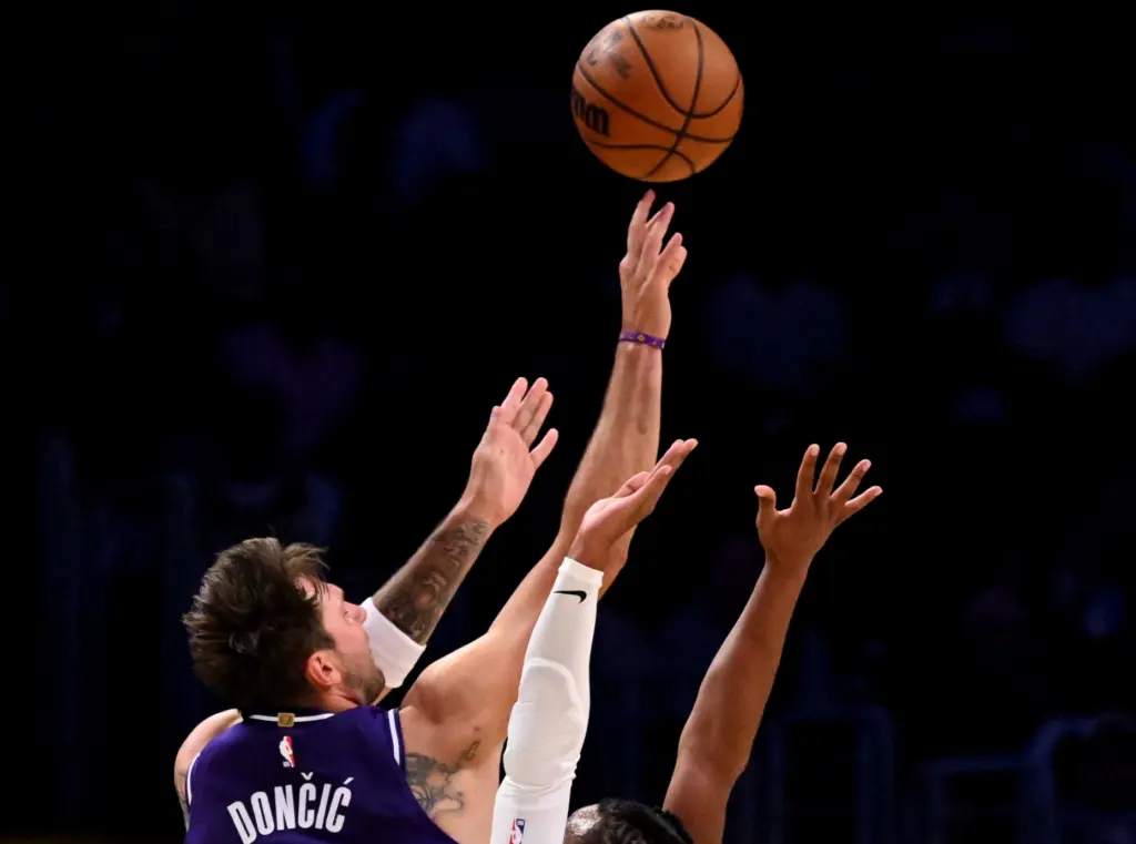 Lakers star Luka Doncic, left, shoots over Clippers guard Darius...