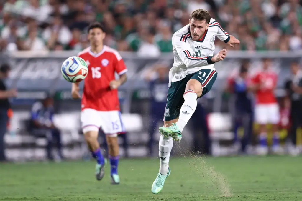 Mexico forward Santiago TomÃ¡s Gimenez, right, takes a shot on...