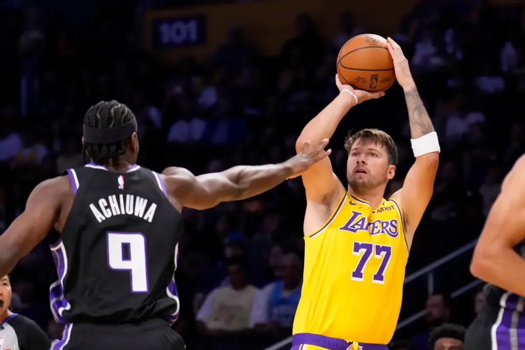 Lakers star Luka Doncic, right, shoots as Sacramento Kings forward...