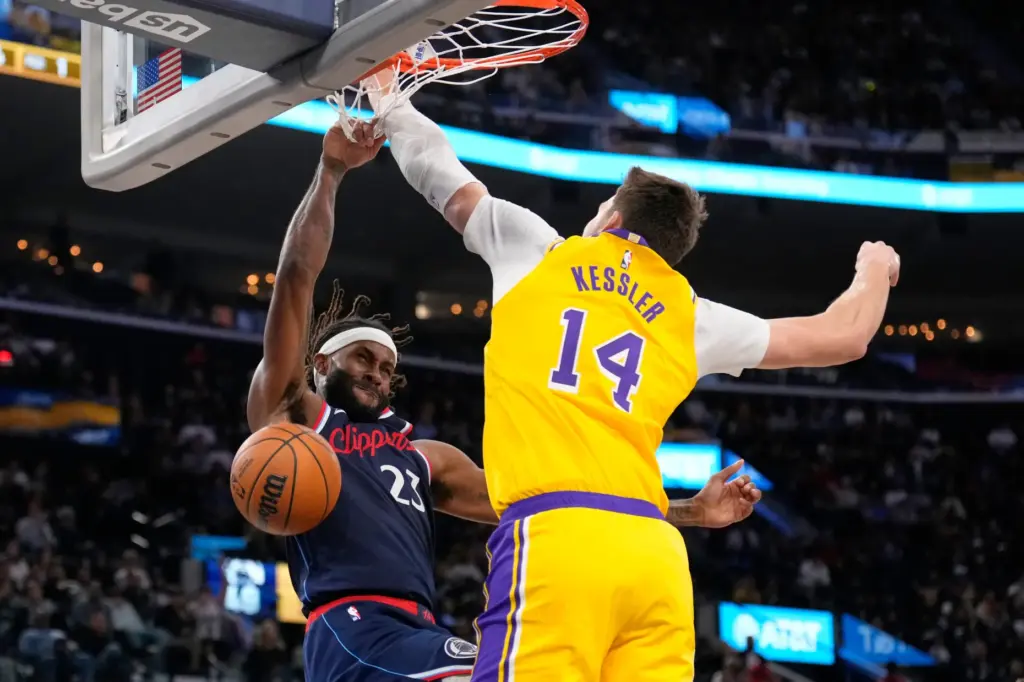 Clippers forward/center Isaiah Jackson, left, dunks as Lakers center Walker...