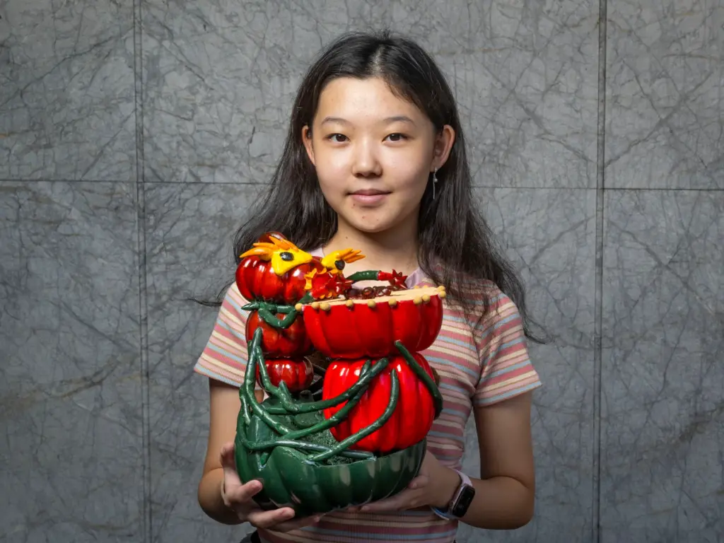 Evelyn Xia holds her pumpkin titled âThe Pumpkin Drummerâ which...
