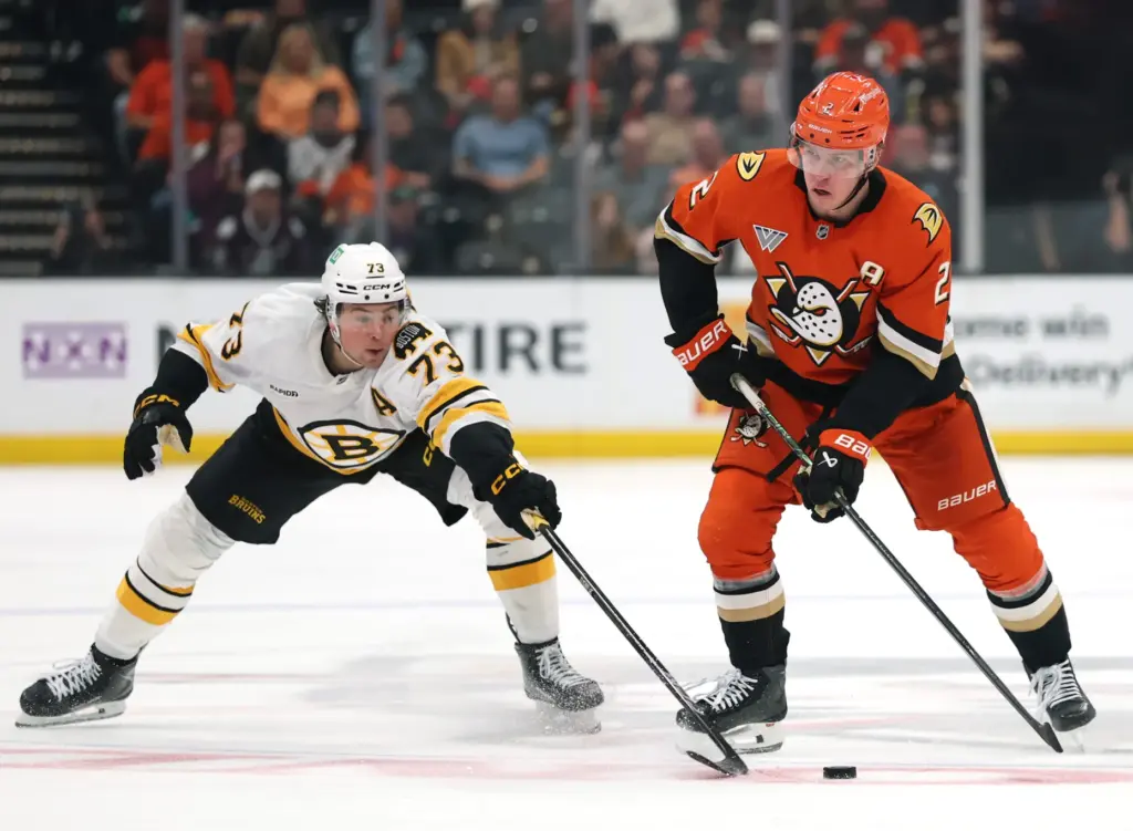 The Ducks’ Jackson LaCombe, right, keeps the puck from the...