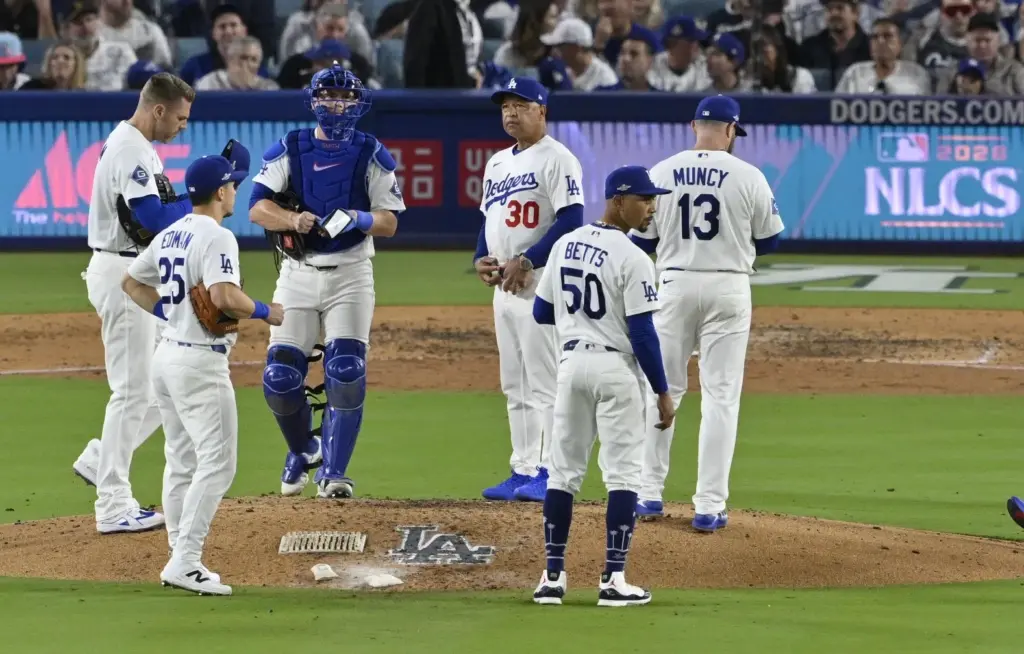 Dodgers manager Dave Roberts (30) waits on the mound for...