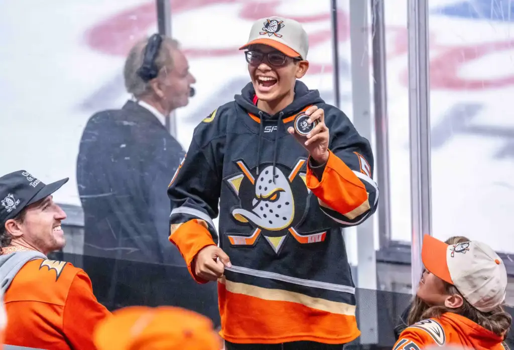 A Ducks fan celebrates after catching a puck that flew...