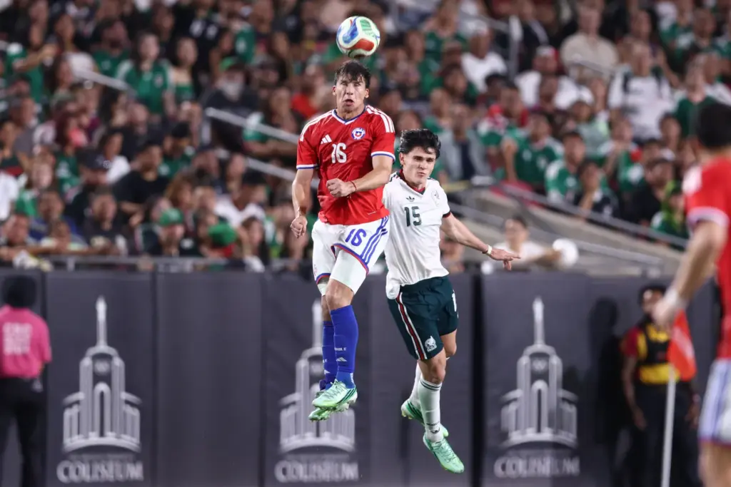 Chile forward Gonzalo Tapia, left, heads the ball in front...