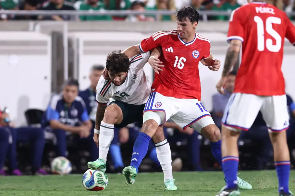 Chile forward Gonzalo Tapia (16) holds Mexico midfielder Denzell, left,...