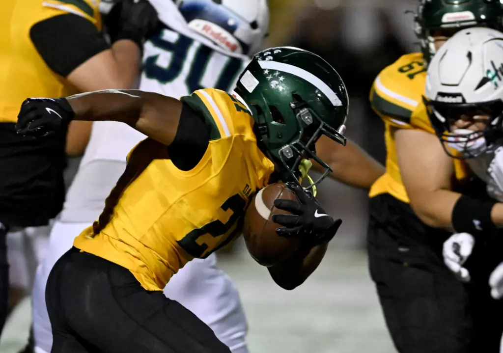 Damien Spartans Malcolm Isaac (21) runs the ball for a...