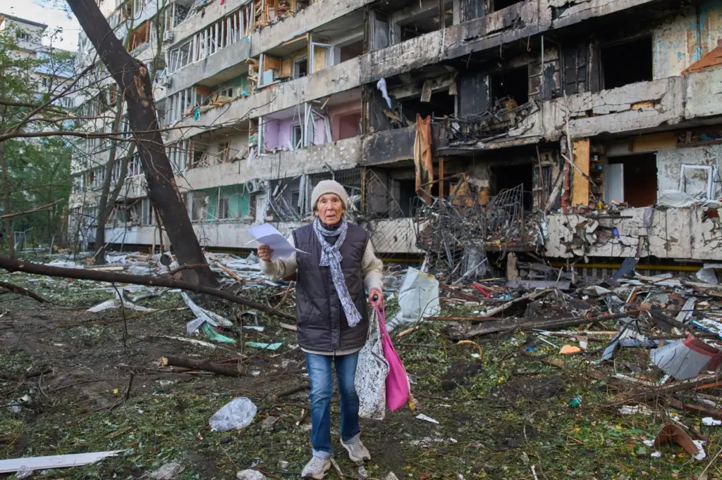 An elderly woman leaves her damaged home after Russia's night missile attack.