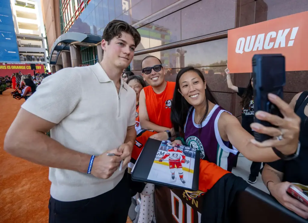 Ducks player Judd Caulfield signs autographs on the orange carpet...