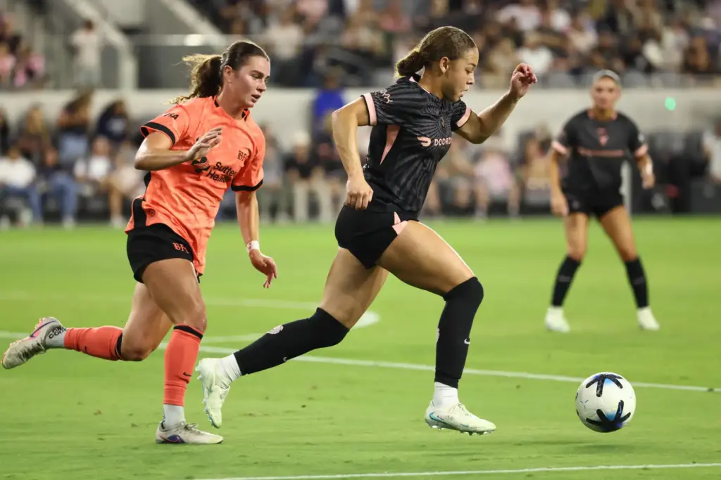 Angel City FC defender Savy King, right, moves the ball...
