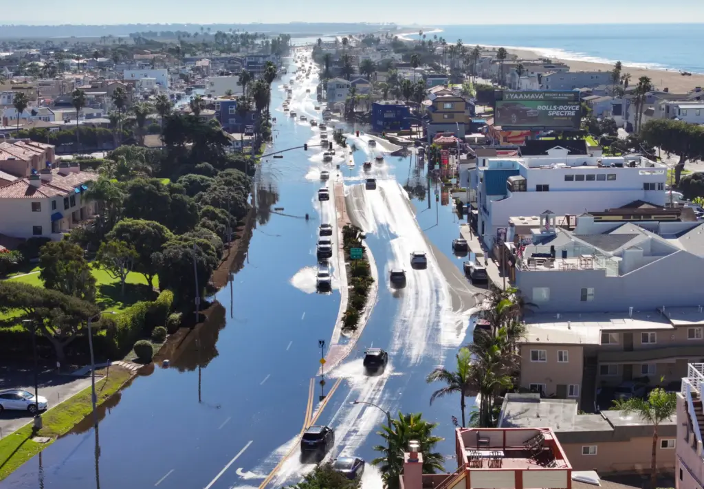 Sea water floods on to Pacific Coast Highway during high...