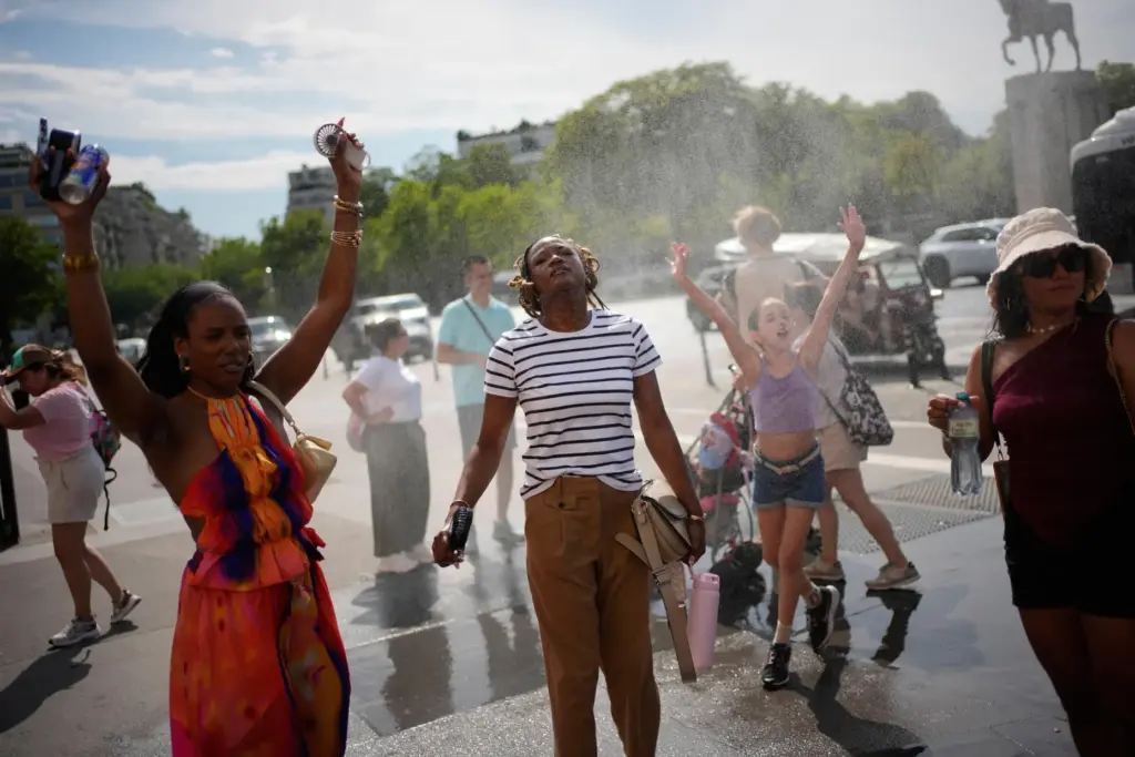 FILE – People cool off at a public water fountain...