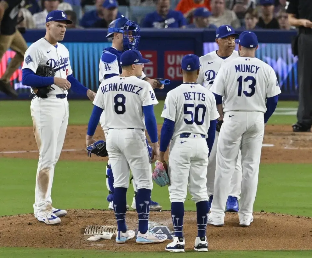 Dodgers manager Dave Roberts, top right, waits on the mound...