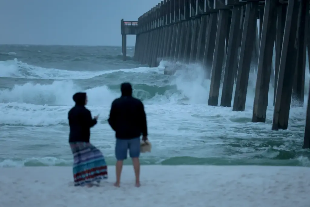 People look out at the waves churning in the ocean...
