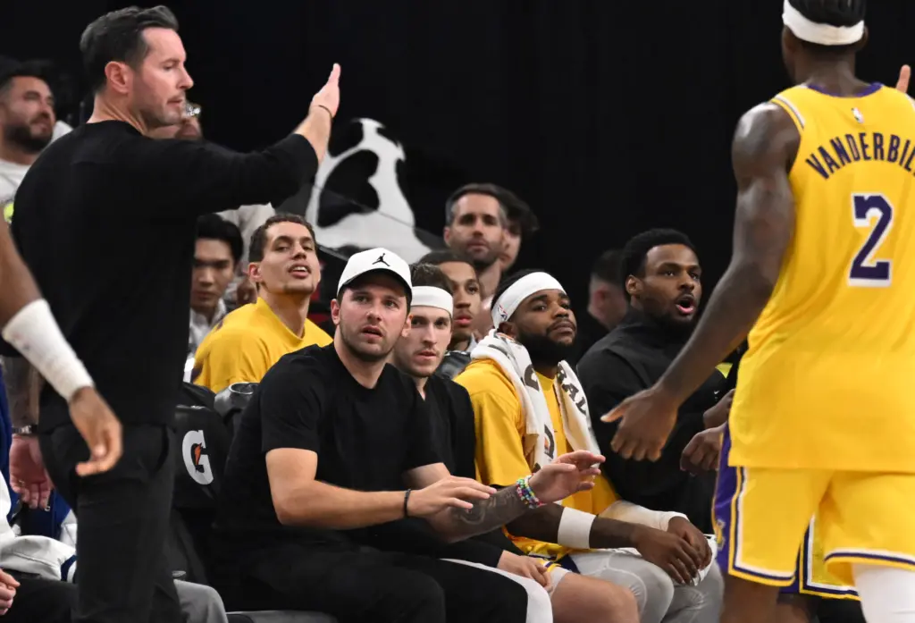 Lakers star Luka Doncic, in street clothes, looks on from...