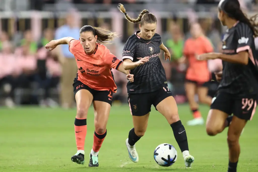 Angel City FC forward Ally Sentnor, right, pushes the ball...