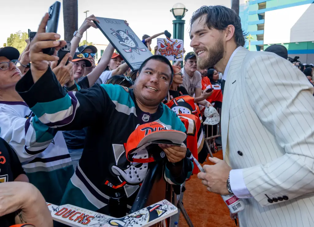 Ducks player A.J. Greer takes a selfie with a fan...