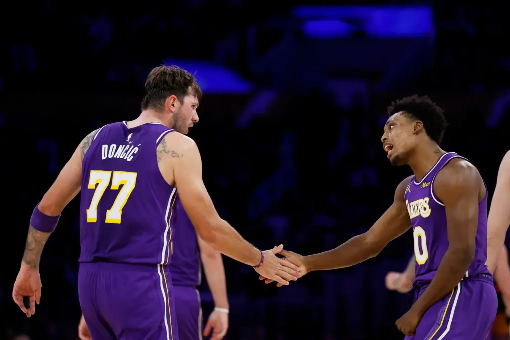 Lakers guard Collin Sexton, right, is greeted by teammate Luka...