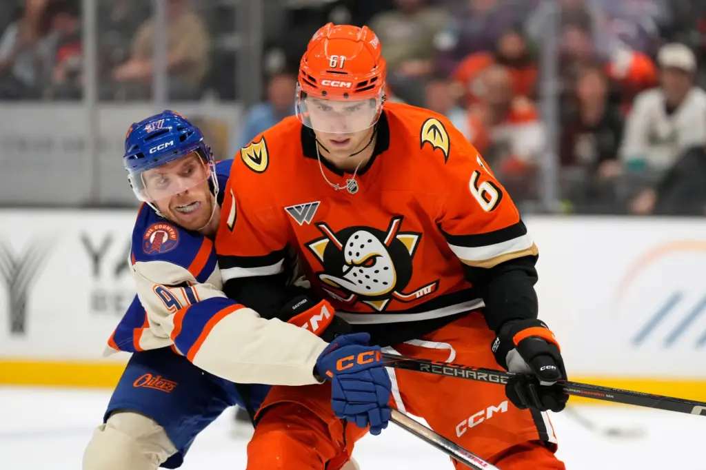 Edmonton Oilers center Connor McDavid, left, reaches in on Ducks...