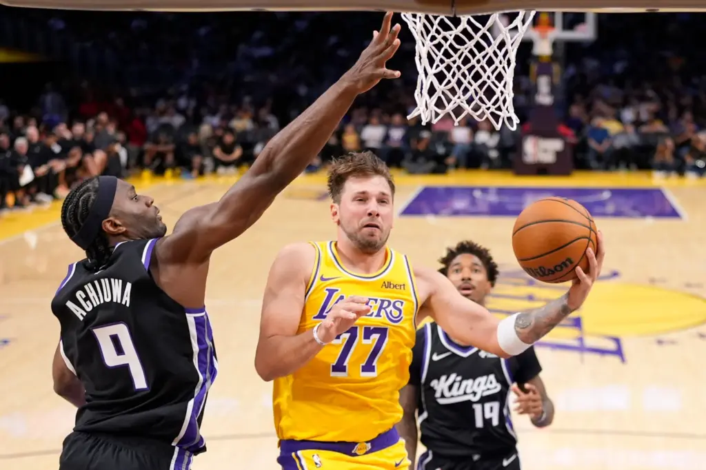 Lakers star Luka Doncic shoots as Sacramento Kings forward Precious...