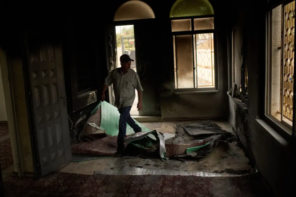 A Palestinian man walks in a mosque that was burned during an attack by Israeli settlers.