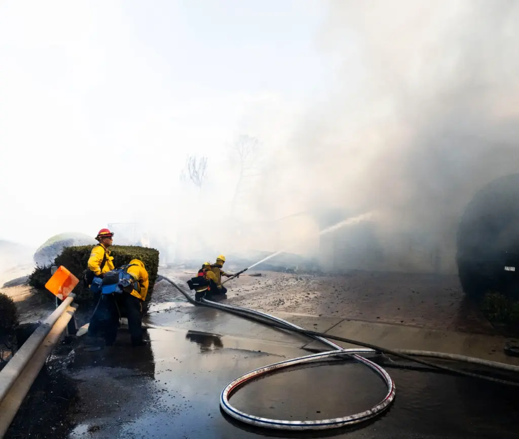 Firefighters work to save structures on Via La Mirada during...