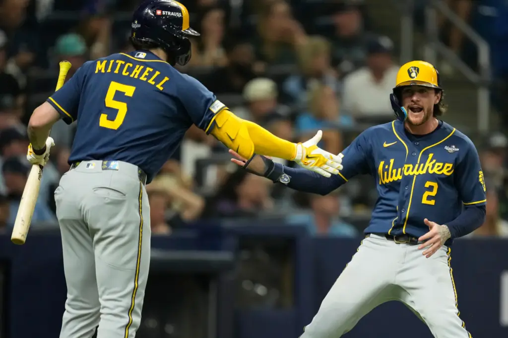 The Milwaukee Brewers’ Brice Turang, right, celebrates after scoring on...