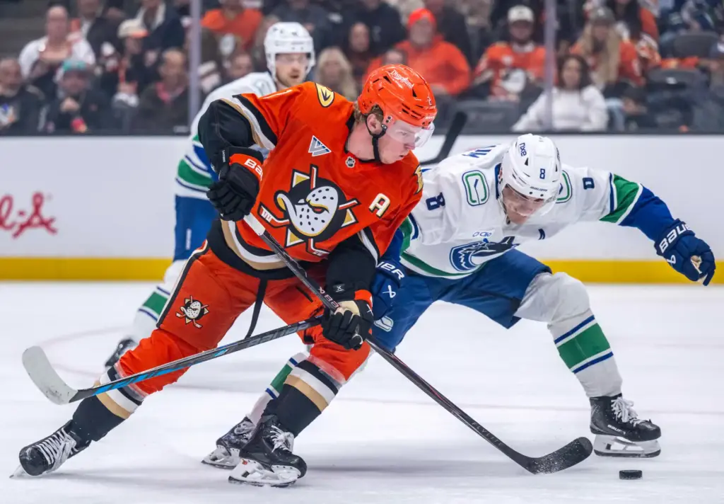 The Ducksâ Jackson LaCombe, left, and Vancouver’s Zeev Buium battle...