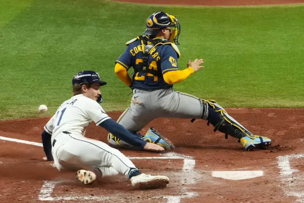 The Tampa Bay Rays’ Jonny DeLuca scores past Milwaukee Brewers...