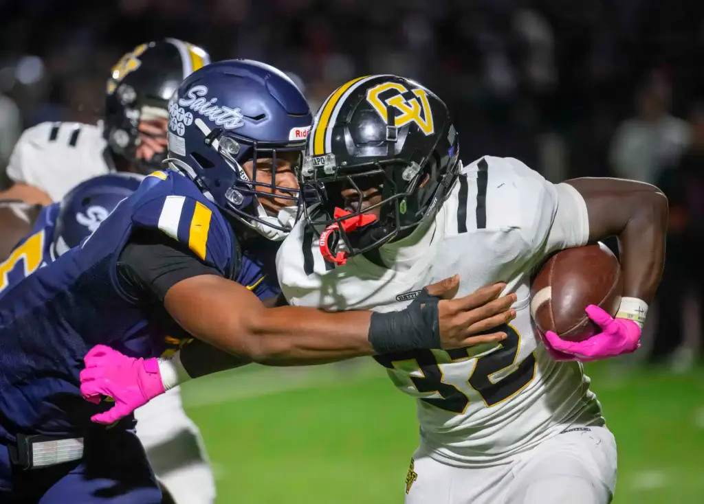 Capistrano Valley running back Zadyn Hall, right, tries to get...