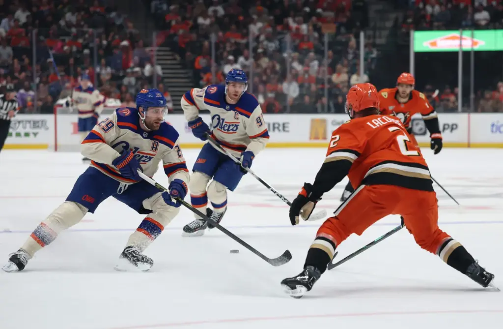 The Edmonton Oilers’ Leon Draisaitl, left, drops a pass to...