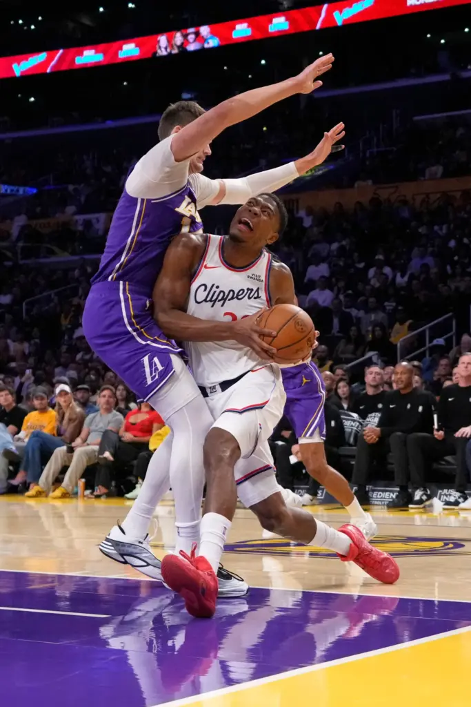 Clippers forward Rui Hachimura, right, tries to drive to the...